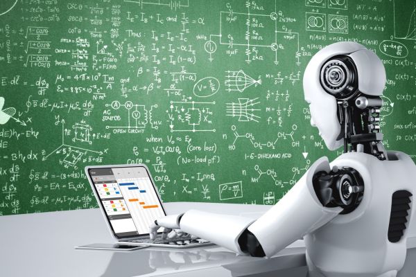 Humanoider Roboter arbeitet am Laptop vor einer Tafel mit komplexen Formeln: Symbolbild für KI im Projektmanagement.
