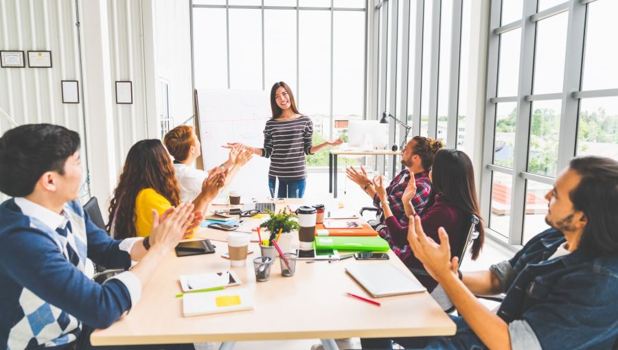 Projektteam applaudiert nach erfolgreicher Präsentation als Symbol für gelungene Kommunikation im Projektumfeld.