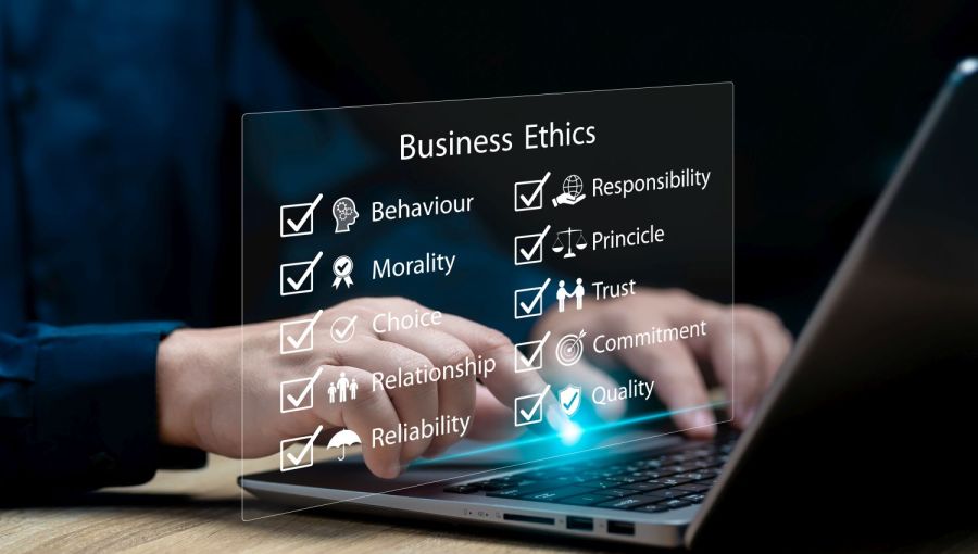 Person tippt auf Laptop mit eingeblendeten Begriffen wie Verantwortung Vertrauen Moral und Qualität als Werte ethischer Unternehmensführung.