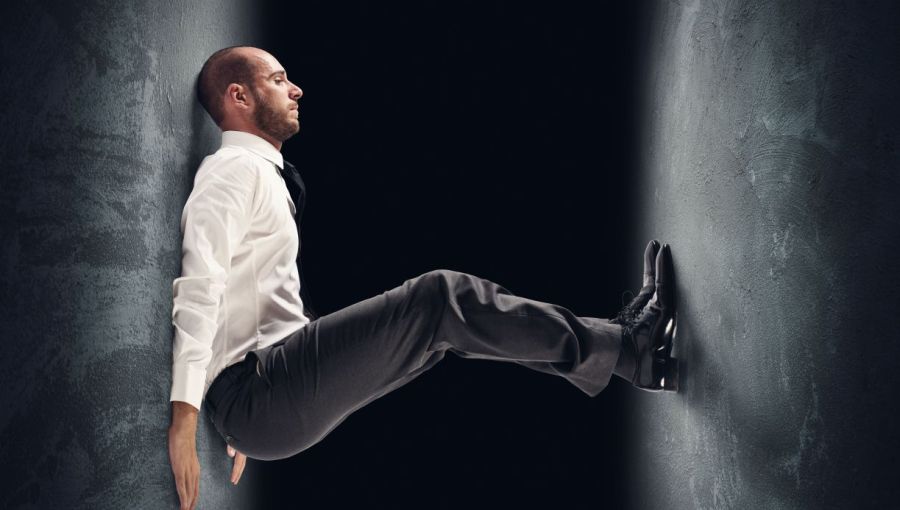 Mann unter Druck. Symbolbild für Leistungsdruck im Berufsalltag: zeigt den mentalen Druck in Projekten durch hohe Erwartungen.