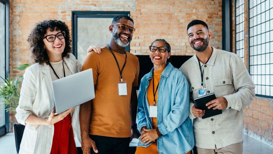 Vier Kollegen im modernen Büro, diverse Teamarbeit und Zusammenarbeit. 