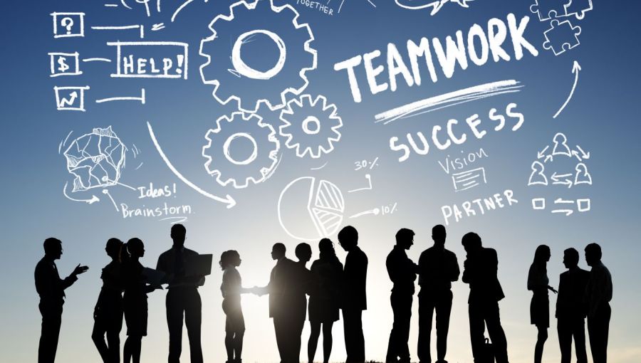 Silhouetten eines Teams vor gezeichneten Symbolen zu Teamwork, Erfolg und Kommunikation: Sinnbild für Zusammenarbeit.